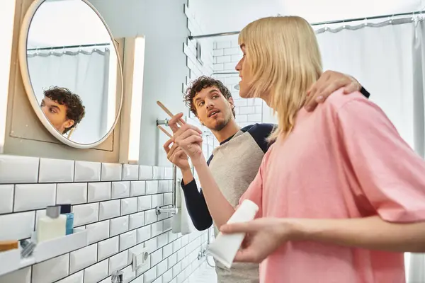 In a cozy bathroom, a gay couple enjoys a playful moment while preparing for their day together. — Stock Photo