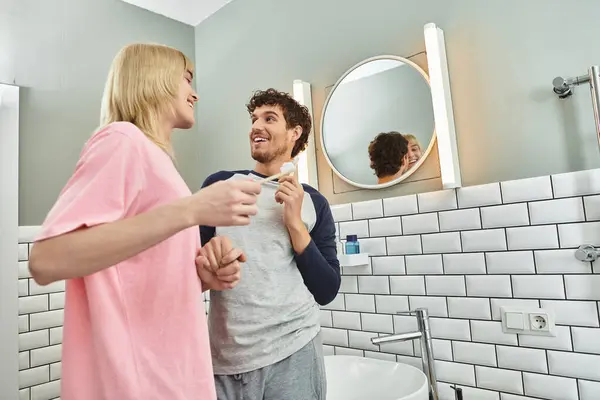 Two men share a joyful morning in their bathroom, brushing teeth and enjoying each others company. — Stock Photo
