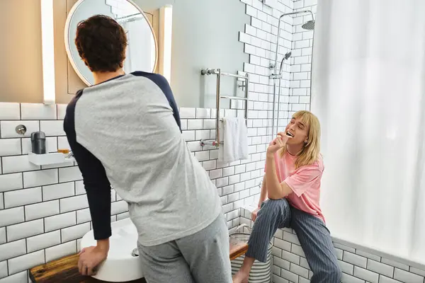 Two men share a joyful moment in their modern bathroom, embodying love and happiness together. — Stock Photo