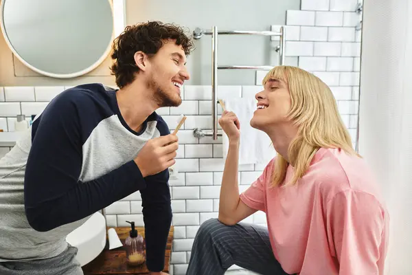 Two men share a playful and loving moment while getting ready together in their stylish bathroom. — Stock Photo