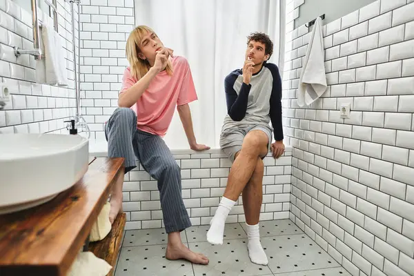 Two men enjoy a quiet time in a stylish bathroom, sharing thoughts and laughter together. — Stock Photo