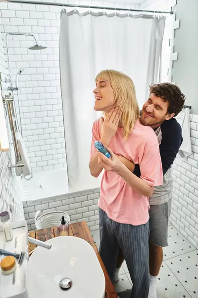 Two men embrace warmly in a sunlit bathroom, cherishing their shared moments of laughter and love. — Stock Photo