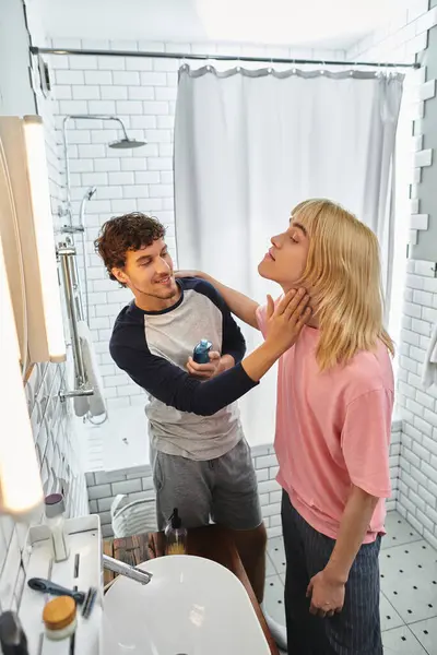 Two loving men tenderly interact while preparing in a bright and stylish bathroom. — Stock Photo