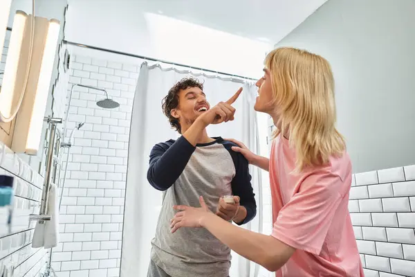 Two men interact playfully while getting ready in their stylish shared bathroom, full of love. — Stock Photo