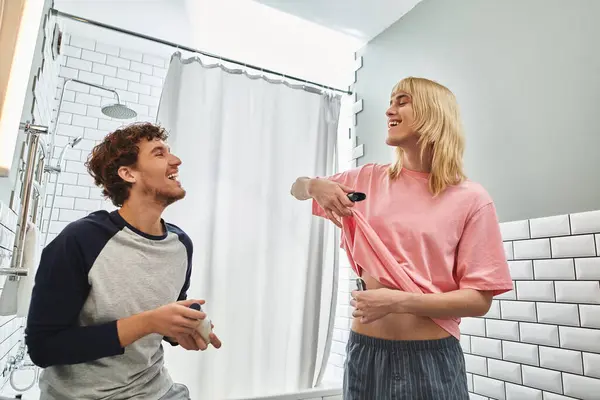 Two men enjoy a playful moment while getting ready in their stylish and bright bathroom. — Stock Photo