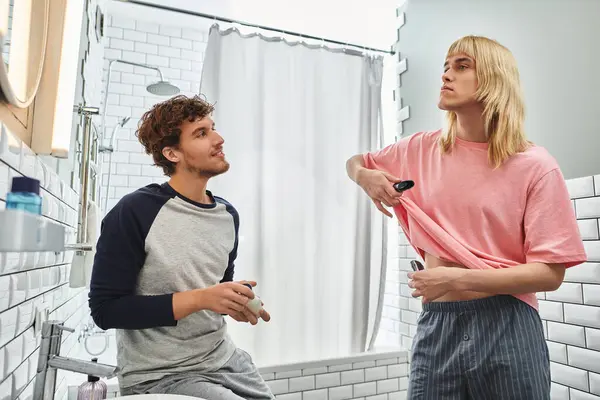 Two men enjoy time together as one playfully lifts his shirt while getting ready. — Stock Photo