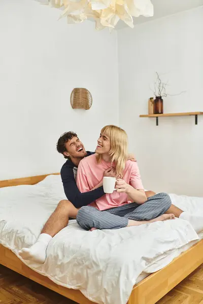 Two happy young men share a joyful moment in their cozy bedroom, surrounded by warmth and love. — Stock Photo