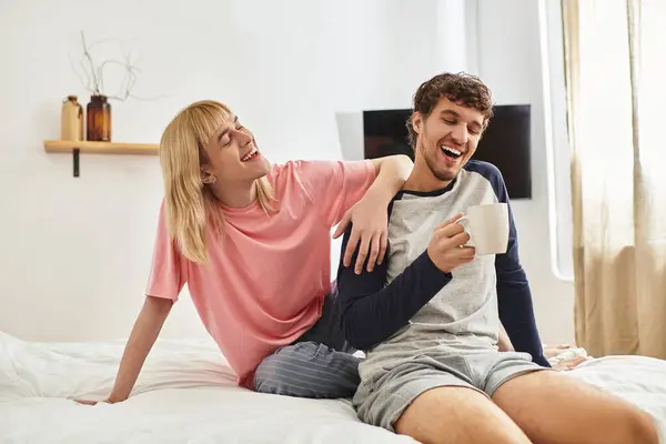 Deux hommes profitent d'une matinée chaude ensemble, partageant des sourires et une tasse de café dans leur espace confortable. — Stock Photo