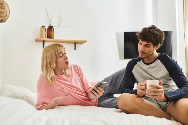 A loving gay couple shares laughter and joy while relaxing together on a comfortable bed. — Stock Photo