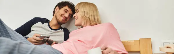 Due uomini condividono sorrisi e calore mentre si godono reciprocamente compagnia in uno spazio informale. — Foto stock