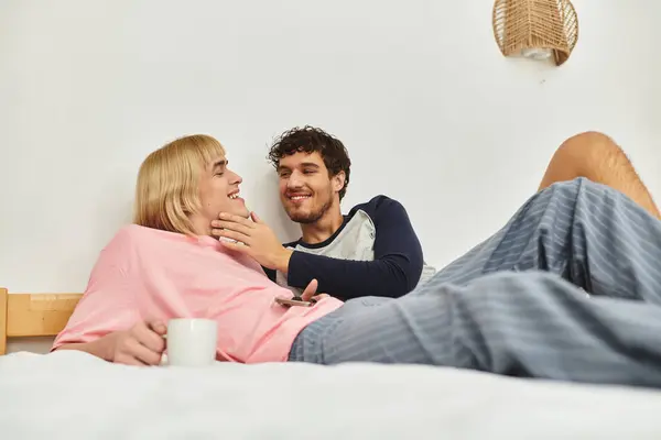Una tenera interazione si svolge mentre due uomini si godono reciprocamente compagnia mentre sono rilassati a letto. — Foto stock