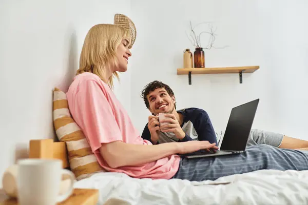 Deux hommes partagent la joie et le rire sur un lit confortable tout en s'engageant dans la conversation et la créativité. — Photo de stock