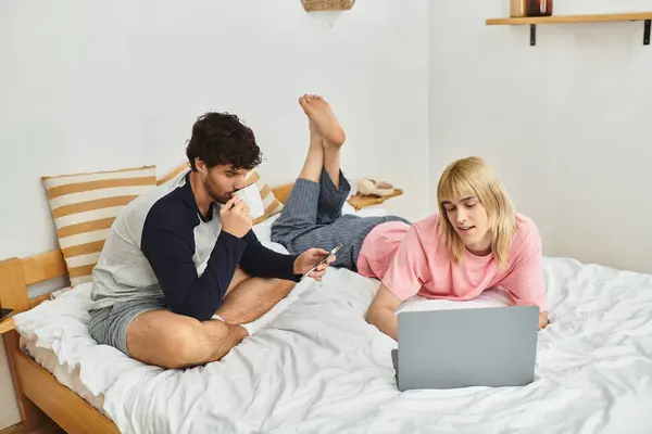 Ein schwules Paar entspannt sich in seinem Schlafzimmer und unternimmt Aktivitäten, während es sich gegenseitig unterstützt. — Stockfoto