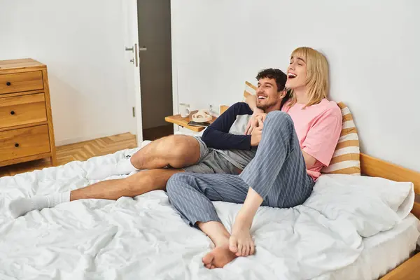 Two men relax on a bed, embracing each other with smiles, enjoying their loving connection. — Stock Photo