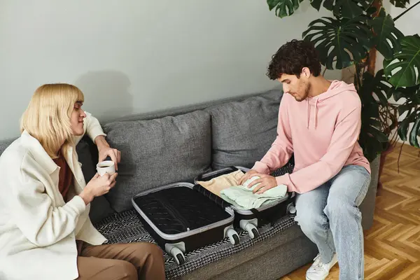 Two men share a tender moment while packing for their trip, surrounded by a warm atmosphere. — Stock Photo