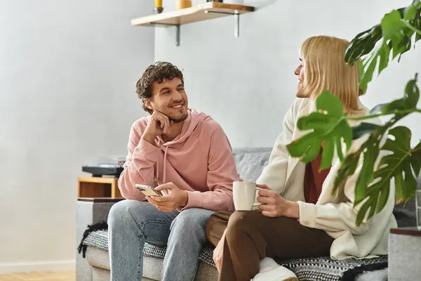 Two men enjoy a warm conversation in their stylish living room, radiating love and joy together. — Stock Photo