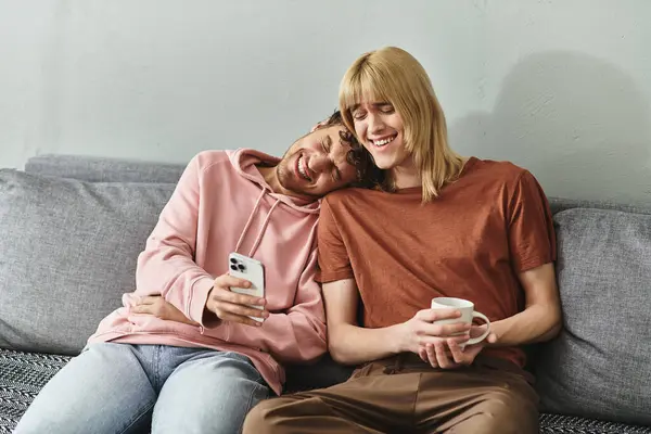 Two men cuddle on a couch, sharing smiles while enjoying a playful moment together. — Stock Photo
