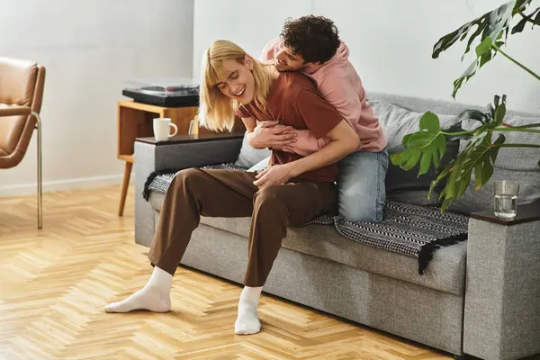 Deux hommes partagent un moment d'amour sur le canapé, profitant de leur compagnie dans un espace chaleureux. — Photo de stock