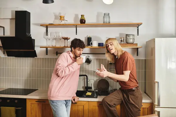 Two men enjoy a warm moment in their stylish kitchen while sharing laughter and love. — Stock Photo
