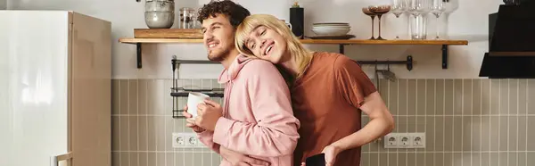 Two men share a warm moment in their kitchen, enjoying smiles and laughter together. — Stock Photo