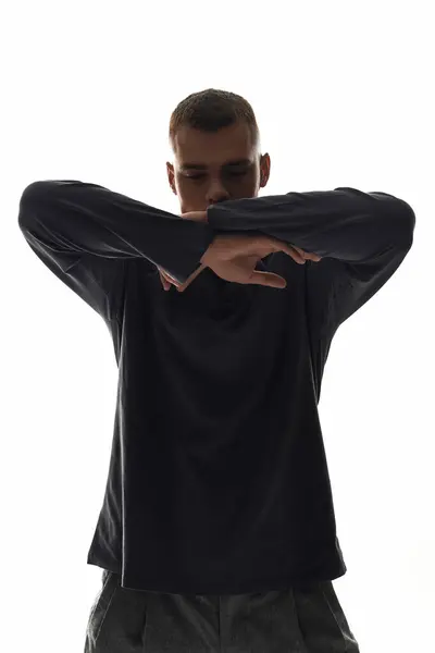 Un jeune homme prenant une pose expressive les bras croisés, faisant preuve de créativité et de confiance. — Photo de stock
