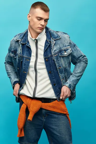 Young man showcases a trendy outfit featuring denim and a relaxed pose, captured in bright colors. — Stock Photo