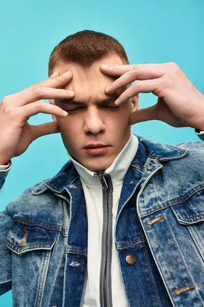 A handsome young man in a denim jacket shows contemplation with a focused expression on his face. — Stock Photo