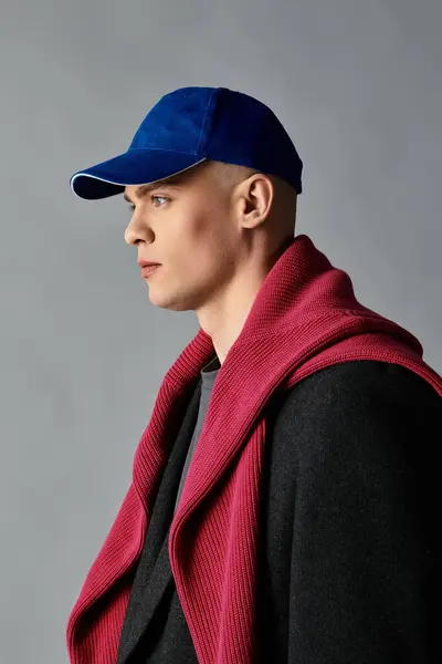 A handsome young man showcases his fashion sense while posing calmly, dressed in trendy layers. — Stock Photo