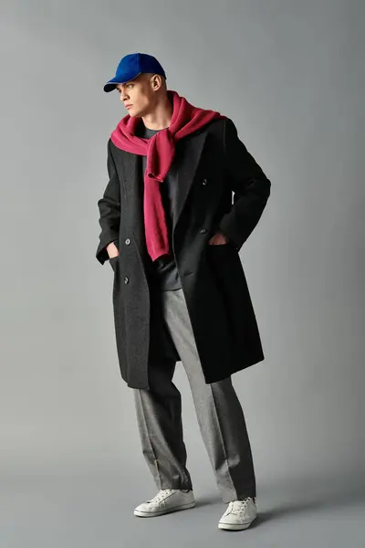 A young man exudes charm and confidence while showcasing a modern outfit with urban flair. — Stock Photo