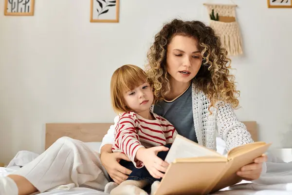 Curly-haired mother and her daughter share a delightful reading moment at home, enveloped in warmth. — Stock Photo