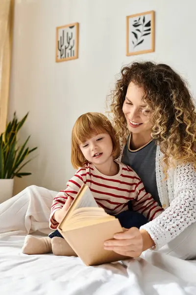 Curly-haired mother and daughter enjoy a heartwarming reading session together in their cozy room. — Stock Photo