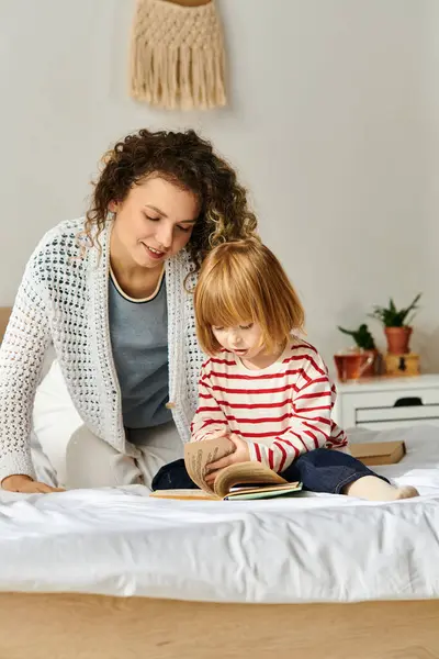 A mother and her daughter joyfully read together on a cozy bed, sharing moments of laughter. — Stock Photo
