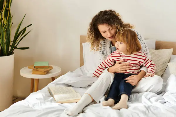Cuddling on the bed, a mother and her daughter share a loving moment surrounded by warmth and joy. — Stock Photo