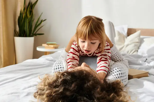 A mother and her daughter share a joyful moment lying on the bed, creating memories together. — Stock Photo