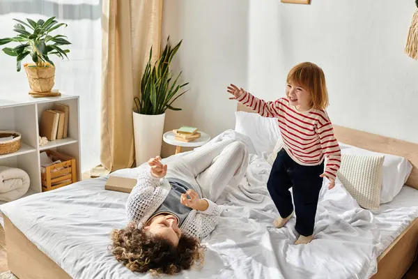 A mother and daughter joyfully play together in a bright, cozy room. — Stock Photo
