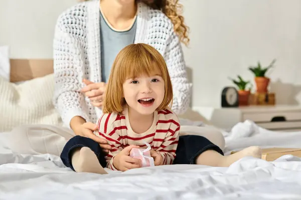 A curly-haired mother and her daughter share joyful moments while playing at home. — Stock Photo