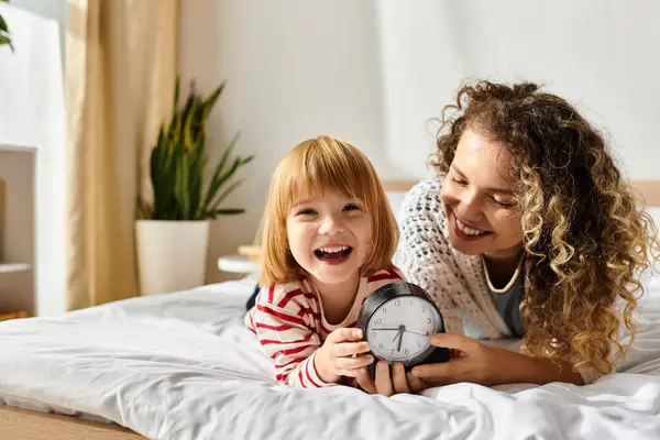 Curly-haired mother and daughter share laughter while playing together in their bright home. — Stock Photo