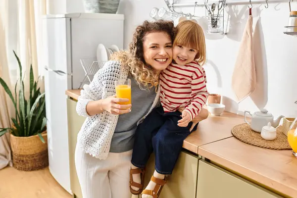 Mãe e filha saborear um momento alegre juntos, compartilhando bebidas e risos em casa. — Fotografia de Stock