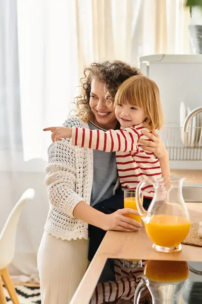 Mother and daughter enjoy playful moments in the kitchen, smiling and sharing a fun activity. — Stock Photo