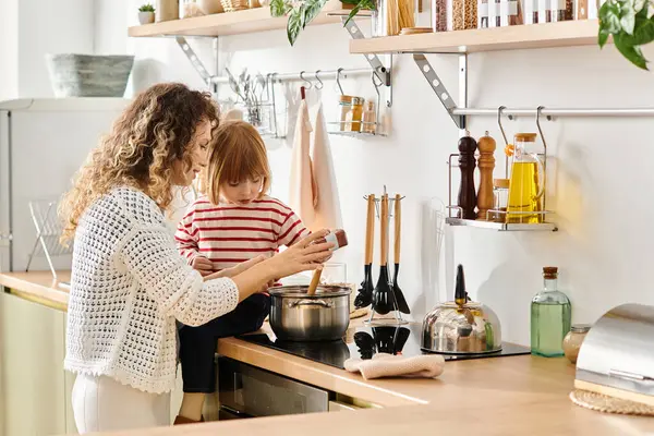 Uma mãe ensina sua filha a cozinhar, ligando-se a uma tarefa compartilhada em sua cozinha. — Fotografia de Stock