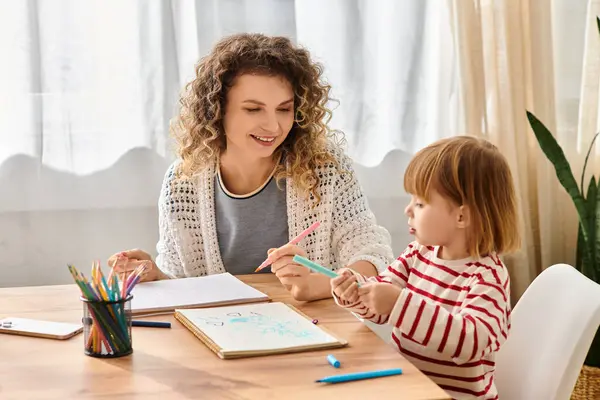 A mother and daughter engage in a fun drawing session together at home, creating memories. — Stock Photo