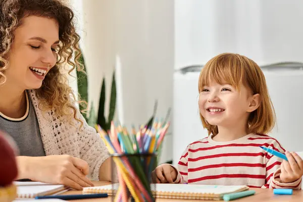 Mother and daughter enjoy a joyful crafting session together at home, fostering creativity. — Stock Photo