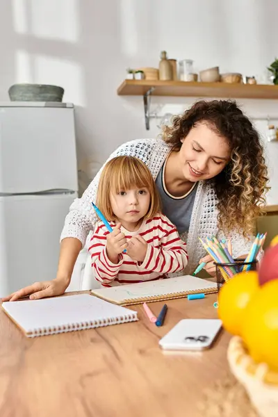 Uma mãe de cabelos encaracolados e sua filha se envolvem em uma divertida atividade de artesanato em casa juntos. — Fotografia de Stock