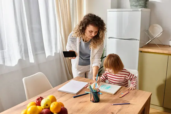 Curly-haired mother assists her daughter as they explore drawing and creativity indoors. — Stock Photo