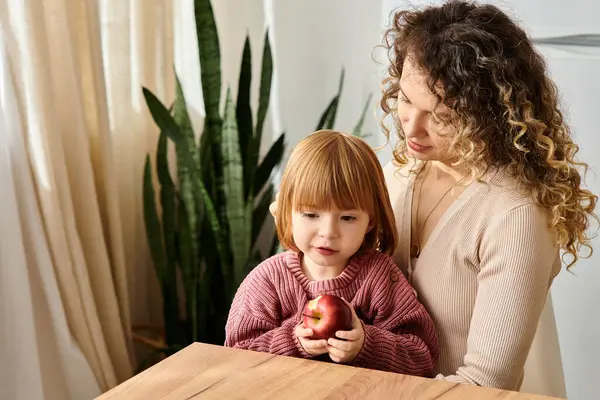 Eine Mutter mit lockigem Haar genießt die Zeit mit ihrer Tochter und fördert Liebe und Verbundenheit. — Stockfoto