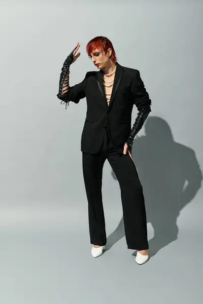 Dressed in a fashionable black outfit, the young man strikes a bold pose, showcasing individuality. — Stock Photo