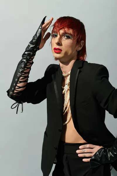 A young man showcases a bold outfit and colorful hair in a stylish, modern setting. — Stock Photo
