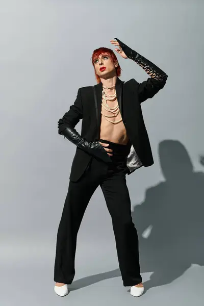 Striking young man showcases bold fashion choices with a confident pose in a minimalist setting. — Stock Photo