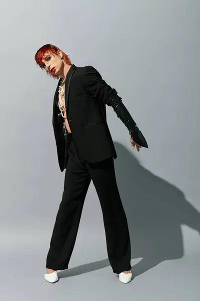 A young man poses confidently in a stylish outfit, demonstrating creative fashion in a studio. — Stock Photo
