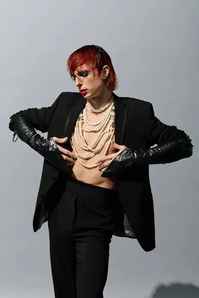 A confident young man showcases bold attire and artistic flair in a studio. — Stock Photo